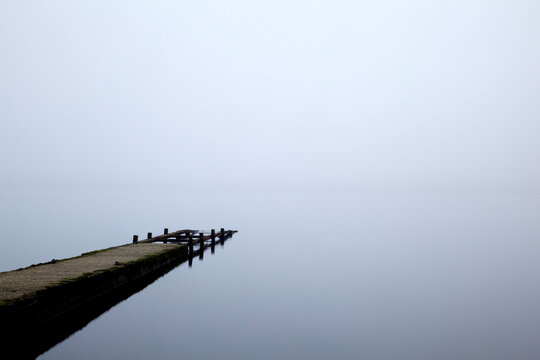 Pier leading into a misty lake