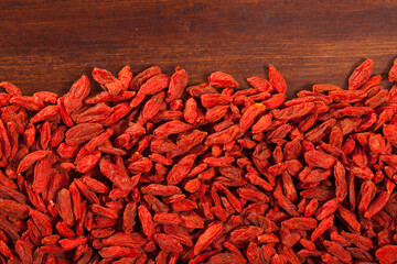 Dried Goji berries on wooden surface - natural background