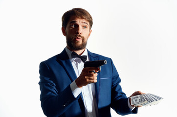 male gangster with a wad of money and a gun in hand in a classic gangster suit