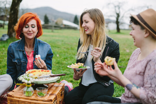 Female Friends laughing having Picnic outdoors