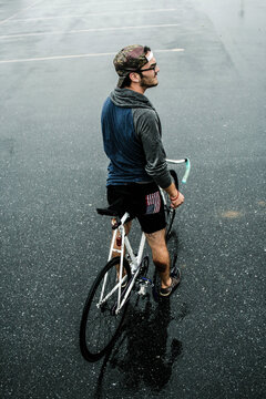 Hip young man relaxes with his fixed gear bicycle