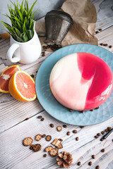 Red and white cake with orange filling. Nearby on a black table are ingredients oranges, nuts. Rustic style