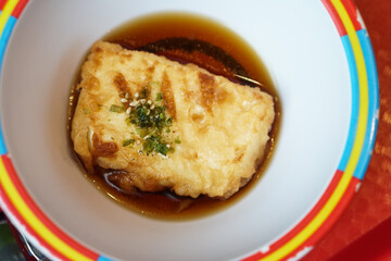 Fried tofu with soy sauce is on colorful bowl