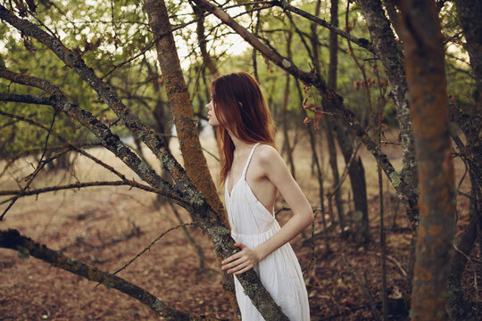 romantic woman in nature near trees in the forest - Powered by Adobe