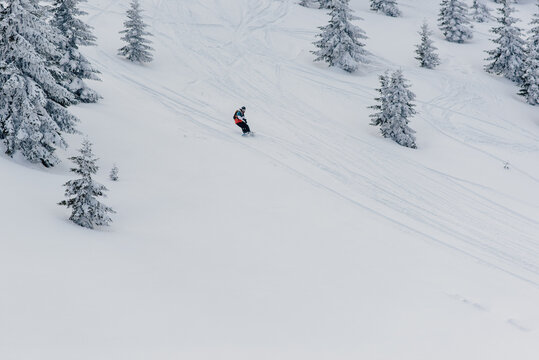 Man riding a snowboard down the slope