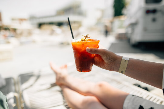 Young Woman Holding Cup Of Bloody Mary Cocktail At Hotel Swimming Pool