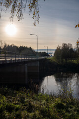 Besides a main road in Finland with low sun with a bridge and river
