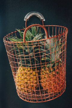 pineapples in a copper wire basket