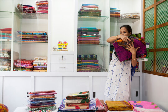 A Businesswoman who sells traditional Indian dress in a small shop