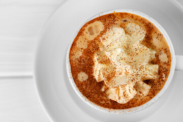 Cup of coffee with whipped cream on white table