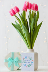 Beautiful flowers, gift and greeting card for Mother's Day on light background