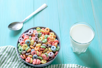 Colored fruit grain loops with a glass of milk on the table. breakfast concept
