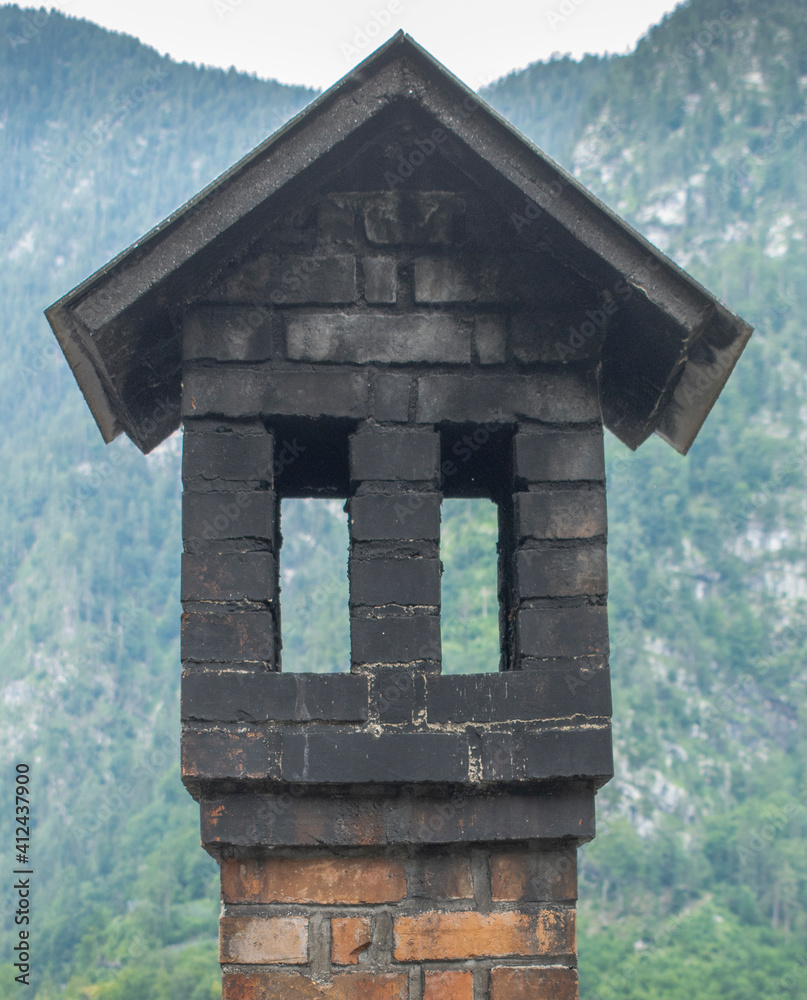 Wall mural old traditional chimney in the shape of a small house with roof and windows. unusually shaped chimne