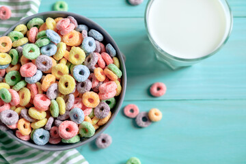 Fototapeta na wymiar Colored fruit grain loops with a glass of milk on the table. breakfast concept