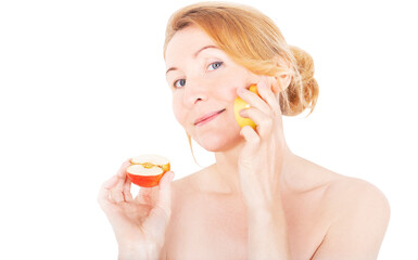 A woman moisturizes her face with half a fresh apple