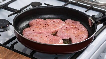 Turkey breast steaks are fried in a pan, close-up