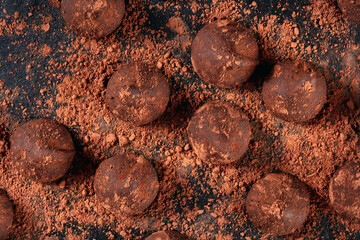 Chocolate truffles, overhead close-up shot on a black background