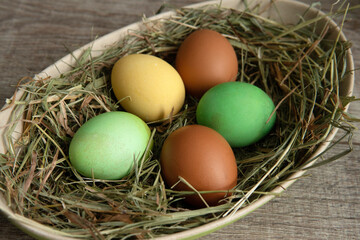 colorful eggs in a basket with straw