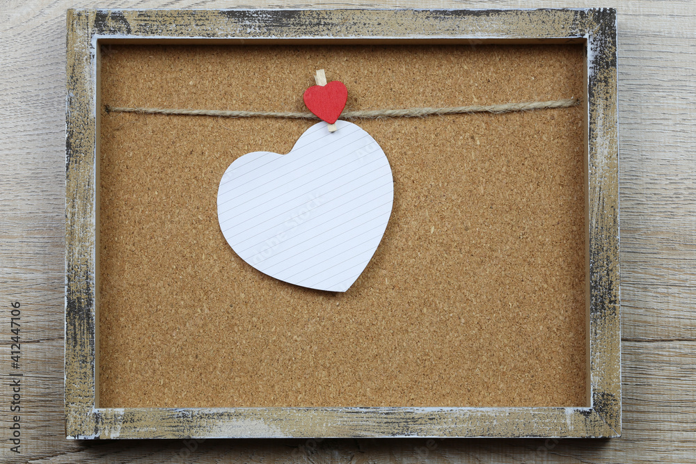 Wall mural Empty heart shape and wooden photo frame.