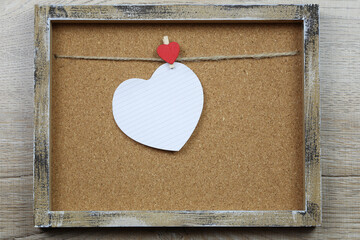 Empty heart shape and wooden photo frame.
