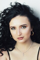 Naklejka premium Beautiful young brunette model with bright make-up and curly hairstyle