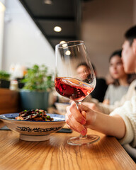 Side view on hand holding a wine glass of aperole cocktail