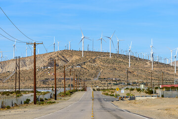 Long straight road with windmills background at California, USA.