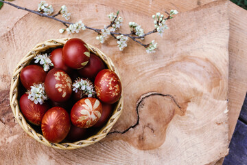 Basket with easter red eggs on rustic wooden table. Place for text. Top view.