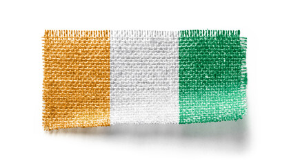 Cote dIvoire flag on a piece of cloth on a white background