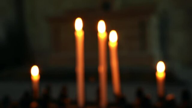 Closeup of burning candles inside an Italian Catholic church