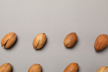 Flat lay with tasty pecan nuts on gray background