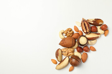 Different tasty nuts on white background, space for text