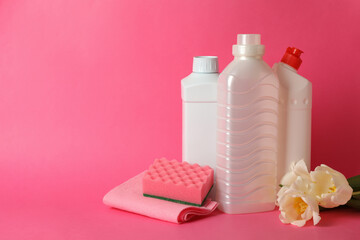 Cleaning tools and tulips on pink background