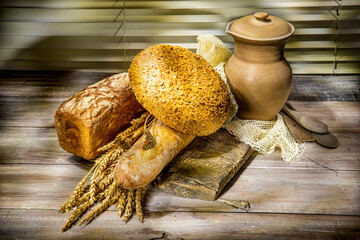 Bread, bun, wheat, clay jug on wooden background