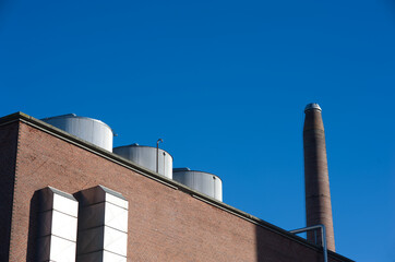 Obraz premium Aarhus, Denmark - 2021 - Industrial plant chimneys against a blue sky 