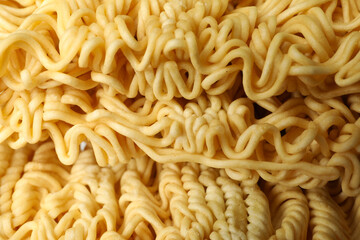 Uncooked instant noodles on whole background, close up