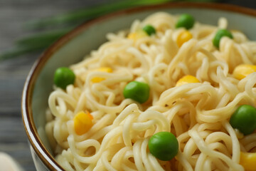 Plate with cooked noodles and vegetables, close up