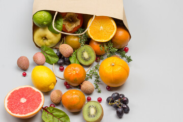 Fruits in paper bag. Persimmon, kiwi and orange on table