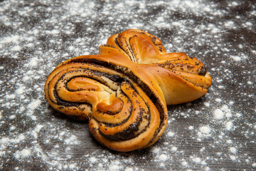 Butter bun with poppy seeds on wooden background