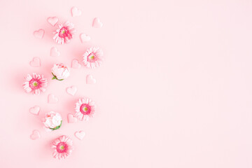 Fototapeta na wymiar Valentine's Day background. Pink flowers, hearts on pastel pink background. Valentines day concept. Flat lay, top view, copy space