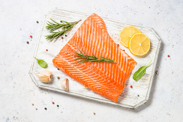 Salmon fillet with sea salt and rosemary. Raw fish. Top view at white table.