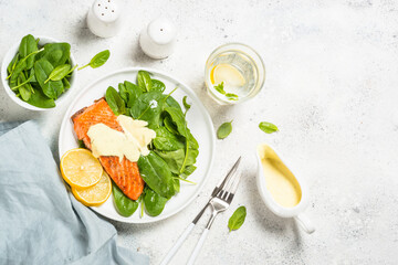 Salmon fillet with spinach and mustard yogurt dressing. Healthy food, keto diet. Top view at white.