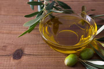 glass vessel with extra virgin olive oil and olives with branch
