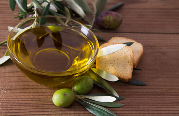 glass vessel with extra virgin olive oil and olives with branch