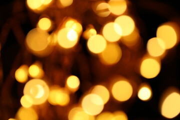 Wallpaper phone shining glitter.Gold  glitter macro background with shining bokeh on a black background. Shining texture.New Year and Christmas background.	Radiant bokeh in warm colors