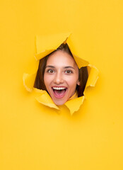 Excited woman in torn paper hole