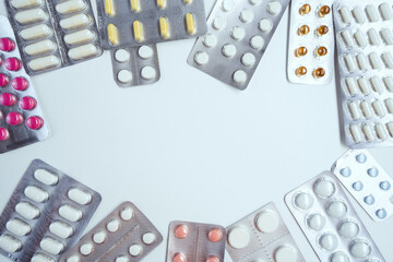 Assorted colored pills and capsules on white background