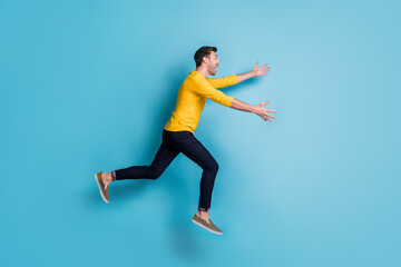 Fototapeta na wymiar Full body profile side photo of cheerful man run jump sale open hands wear casual clothes isolated on blue color background