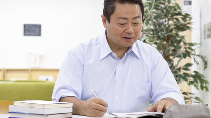 図書館で勉強する中高年男性