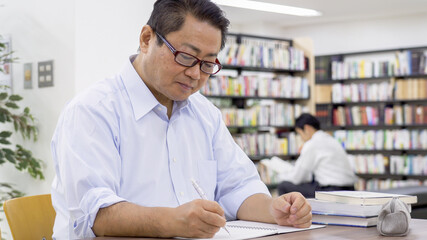 図書館で勉強する中高年男性